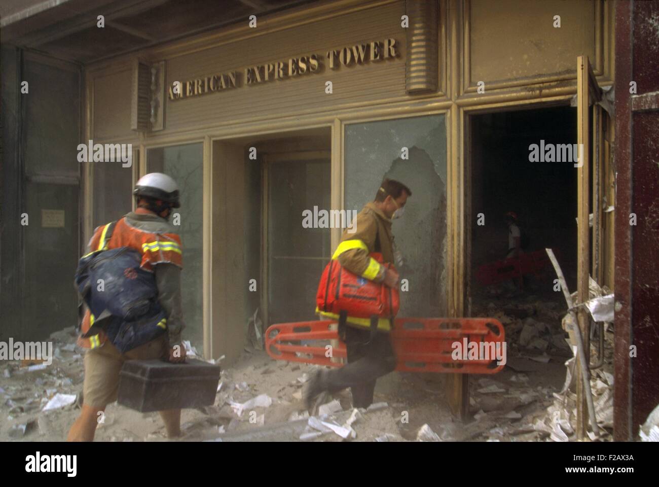 Rescue workers enter the American Express Tower, World Financial Center 3, following 9-11 terrorist attack. They carry orange litters into the debris battered building across the West Side Highway from the World Trade Center complex. (BSLOC 2015 2 60) Stock Photo
