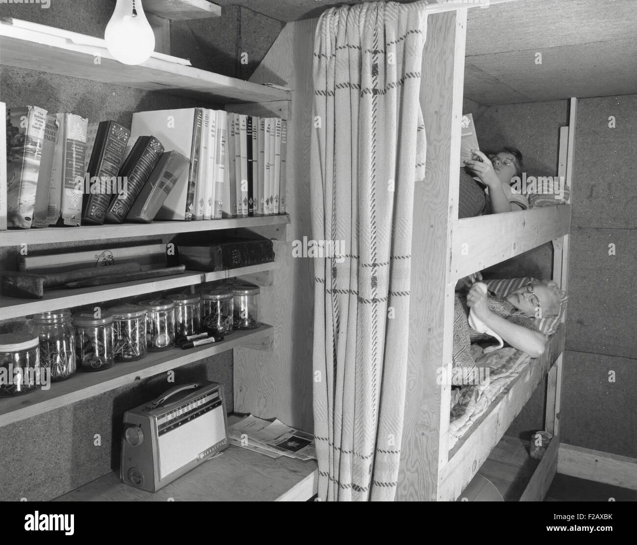 Fallout shelter built adjacent to a home near Akron, Michigan. It has a 10 inch reinforced concrete ceiling with thick earth cover and concrete walls. It includes a special ventilation and escape hatch, a tiny kitchen, running water, sanitary facilities, and a sleeping area for the family of four. Ca. 1960. (BSLOC 2015 2 37) Stock Photo