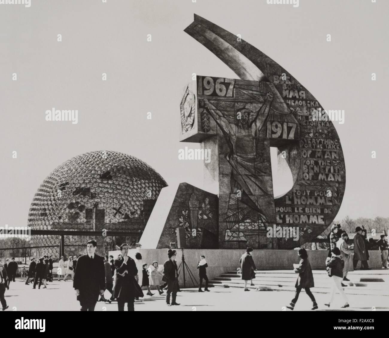 Soviet and U.S. exhibits at the Montreal World's Fair, May 2, 1967. The Soviet Pavilion is a distinctive hammer and sickle monument with expressive art work and the slogan, 'Everything for the sake of man, for the benefit of man'. The dates of 1917 and 1967 are prominent, marking the 50th Anniversary of the Bolshevik Revolution. At left is the U.S. Pavillion, a 20-story geodesic dome by Buckminster Fuller. (BSLOC 2015 2 267) Stock Photo