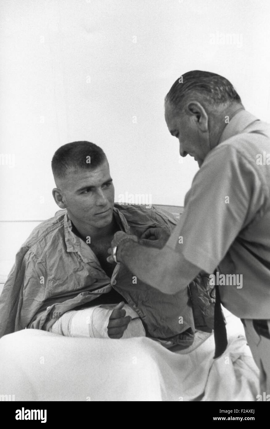 President Lyndon Johnson awards a medal to a wounded U.S. serviceman. Cam Rahn Bay, South Vietnam. Oct. 26, 1966. (BSLOC 2015 2 216) Stock Photo