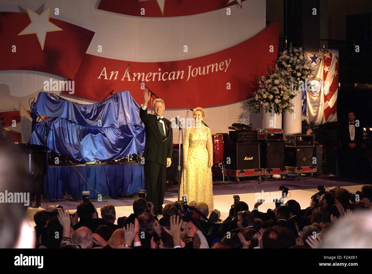 First Lady Hillary Clinton wearing an Oscar de la Renta evening gown at a 1997 Inaugural Ball. President Bill Clinton waves to the crowd beyond the press photographers. Jan. 20, 1997. (BSLOC 2015 2 198) Stock Photo