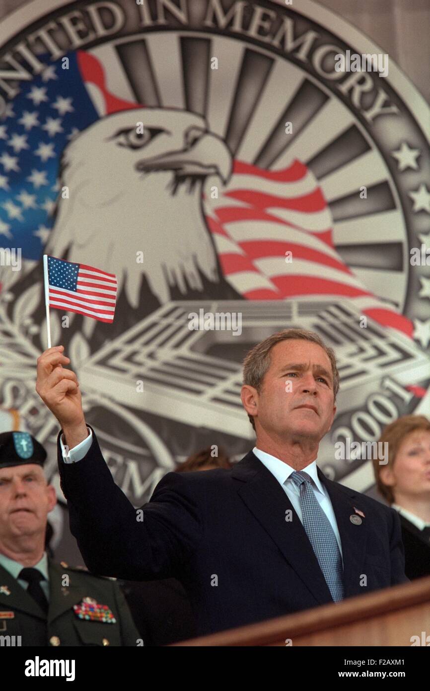 President George W. Bush at Remembrance Service for the 9-11 victims at the Pentagon. Behind Bush 43 is an elaborate backdrop with an eagle and he holds up a small American flag. Oct. 11, 2001, the one month anniversary of the 9-11 Terrorist Attacks. (BSLOC 2015 2 175) Stock Photo