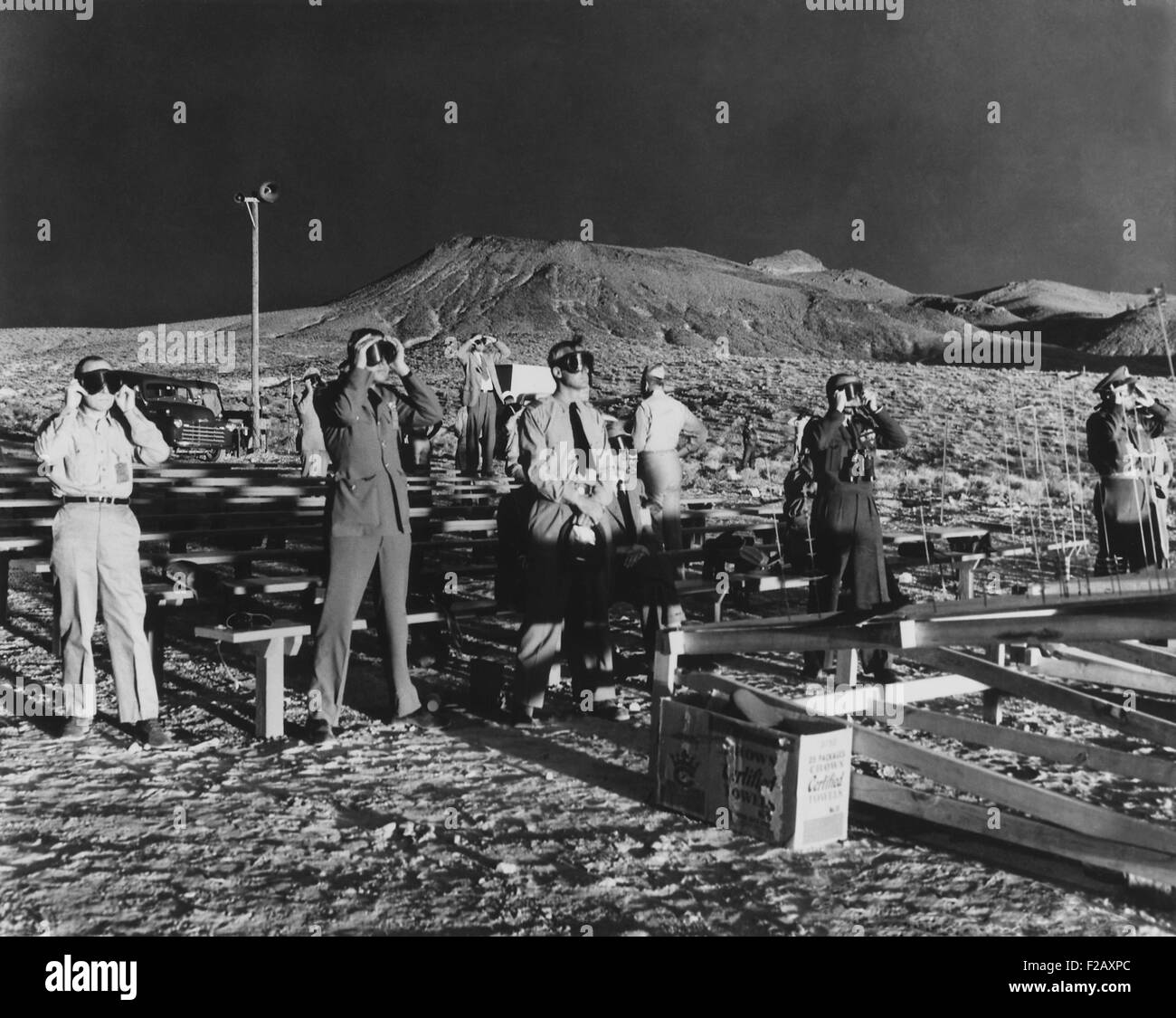 Canadian and British observers illumined by both the sun and an atomic blast of ABLE, a 1-kiloton atomic bomb. January 27, 1951. B-50 Superfortress dropped the first A-bomb of the Operation Ranger series, at the Nevada Proving Ground, in an unpopulated desert 65 miles northwest of Las Vegas. Most observers have goggles, but others without eye protection, stand with their backs to the blast. (BSLOC 2015 2 12) Stock Photo