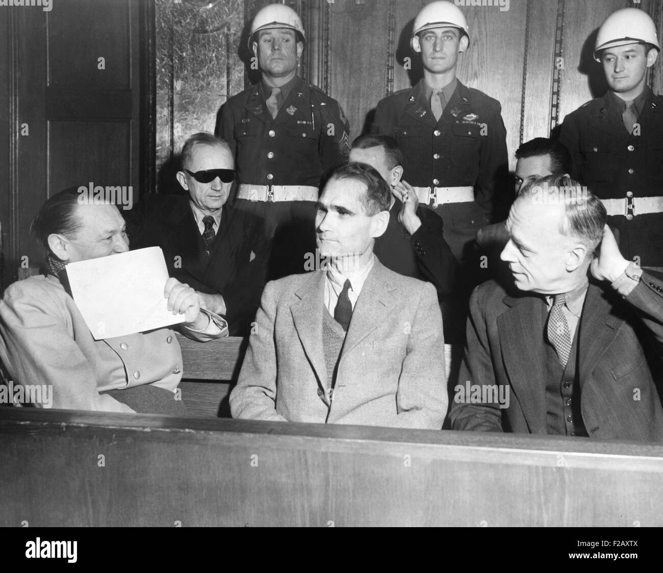 Nazi defendants under guard in the dock at Nuremberg War Crimes Trial, Feb. 5, 1946. L-R: Herman Goering covers his grin with a Stock Photo