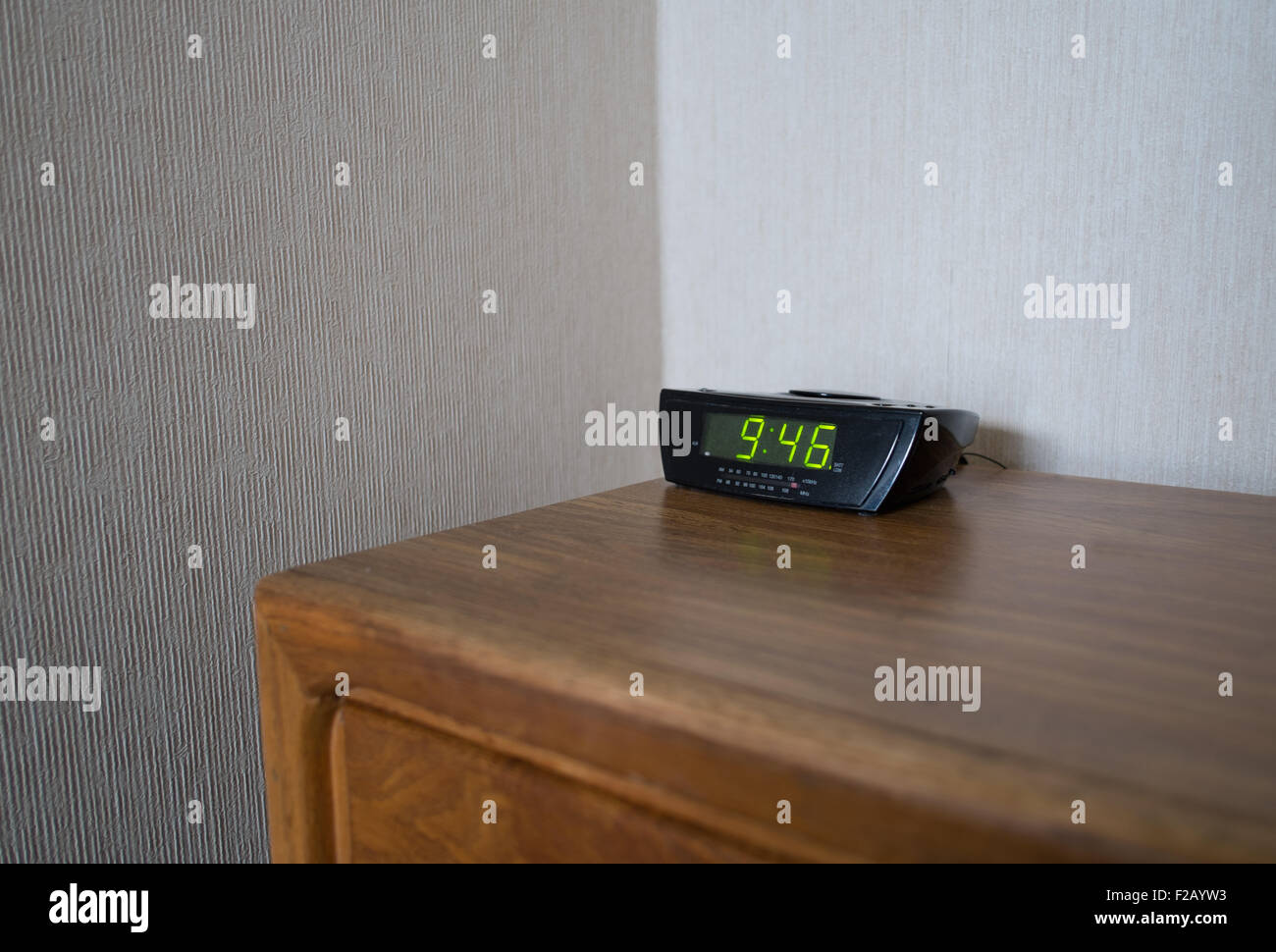 Alarm Clock and bedside table in Motel Stock Photo