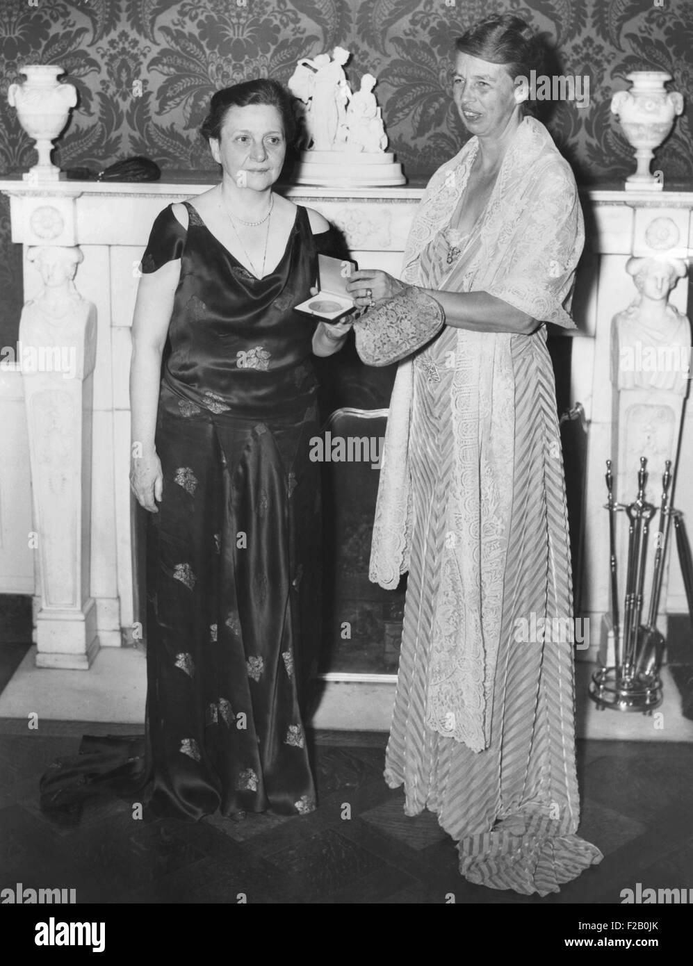 Labor Sec. Frances Perkins receiving a gold medal from Mrs. Eleanor Roosevelt at the White House. Dec. 4, 1934. Perkins was honored as America's Outstanding Woman in the Field of Civic Achievement for 1934, by the Chi Omega Sorority. White House, Washington, D.C. (CSU 2015 9 1073) Stock Photo
