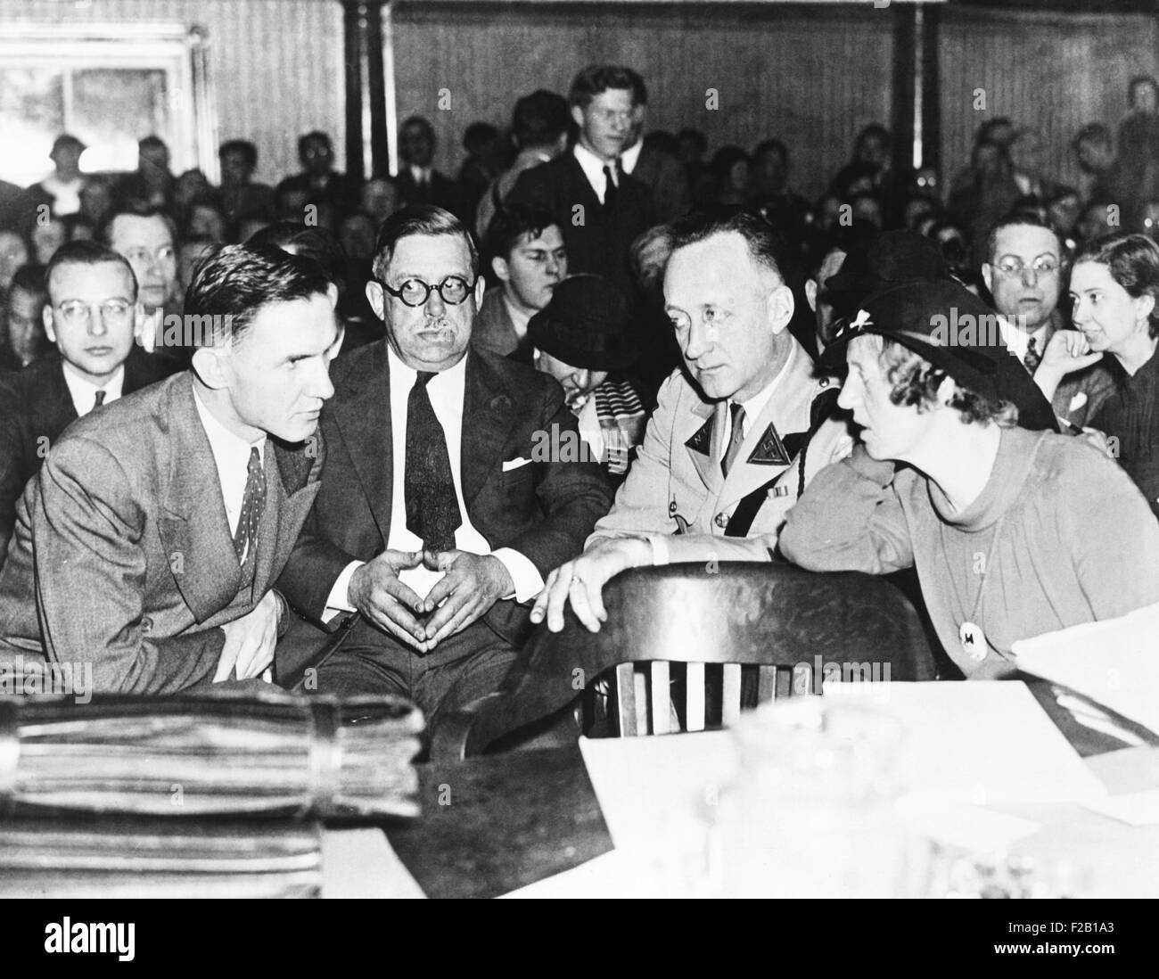 Bruno Hauptmann shown leaning over for a whispered word with his wife, Anna Hauptmann. Deputy Hovey Low and a state trooper are Stock Photo