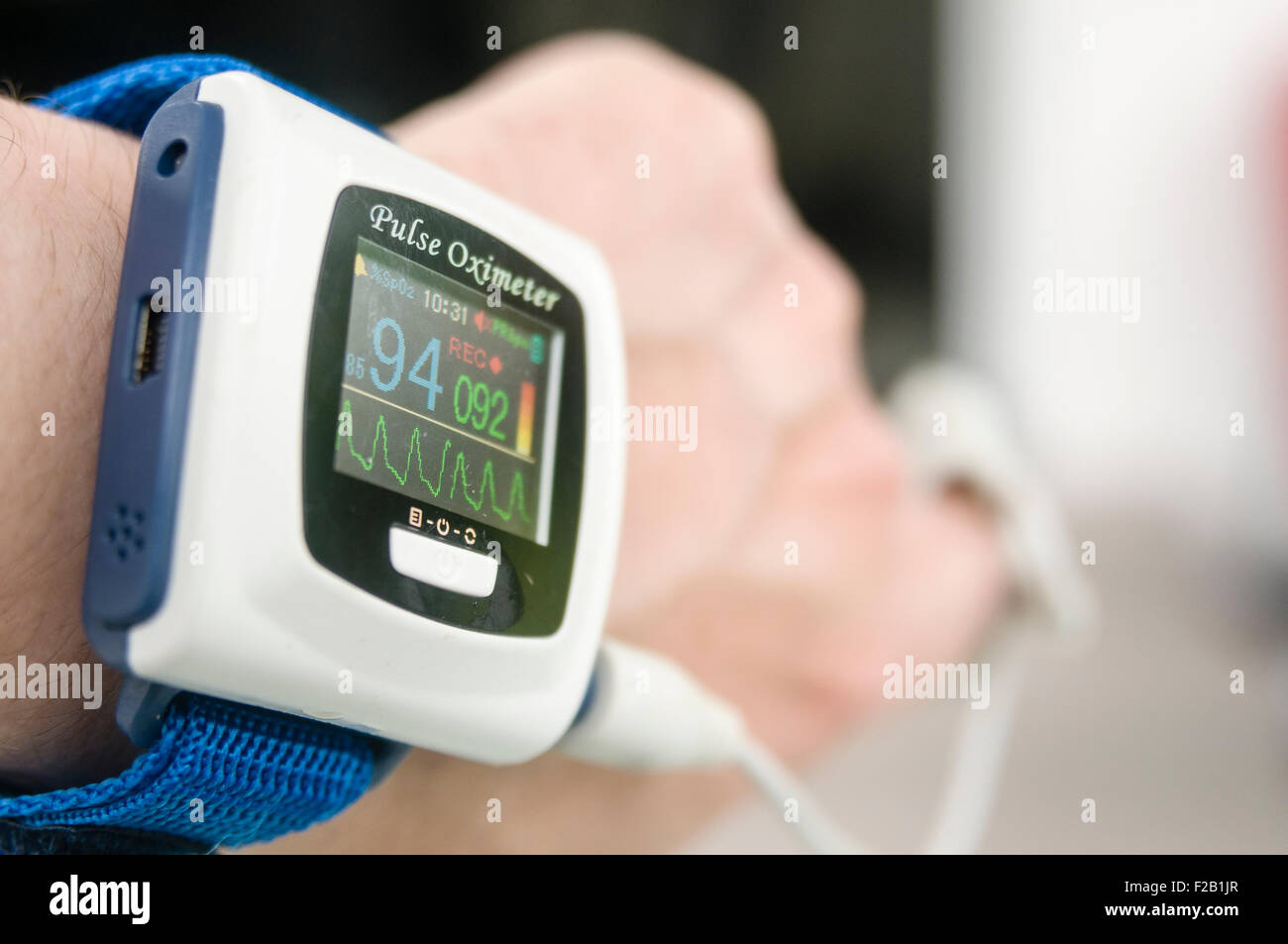 Pulse oximeter being worn by a male patient to measure his blood oxygen saturation level Stock Photo