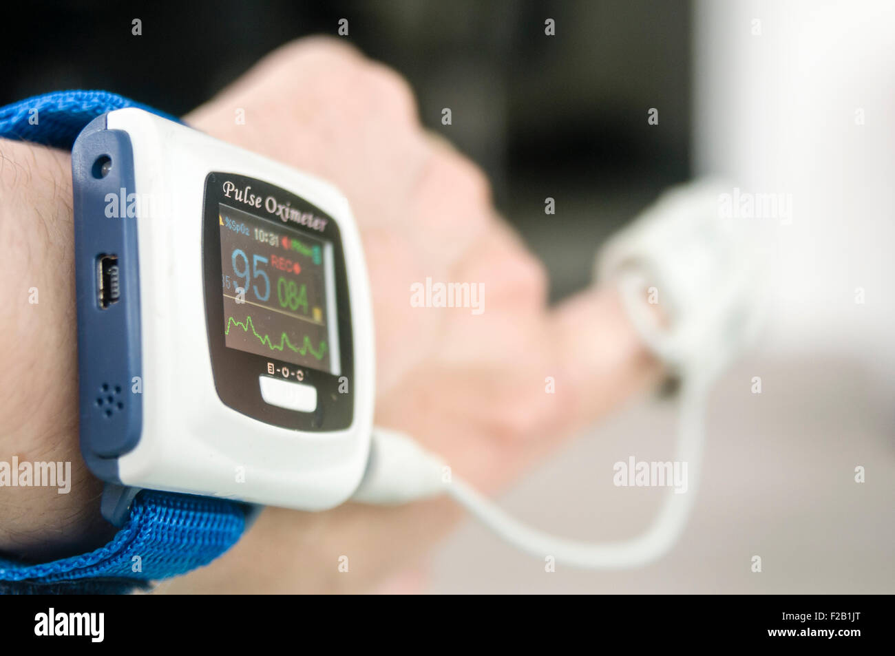 Pulse oxymeter being worn by a male patient to measure his blood oxygen saturation level Stock Photo
