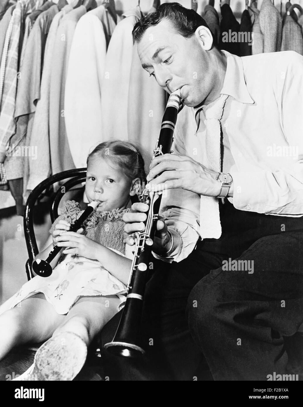 Jazz musician Woody Herman playing his clarinet while his daughter Ingrid plays a plastic flute. Ingrid grew up to become a Bluegrass musician and fiddler. Ca. 1946. (CSU 2015 7 395) Stock Photo