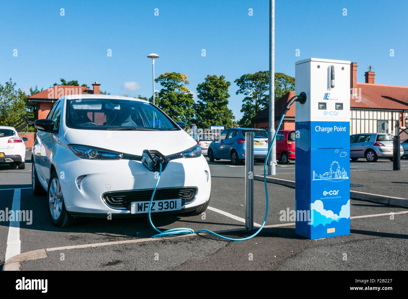 A Renault Zoe electric car is recharged from a Northern Ireland Electricity charging station in a car park Stock Photo