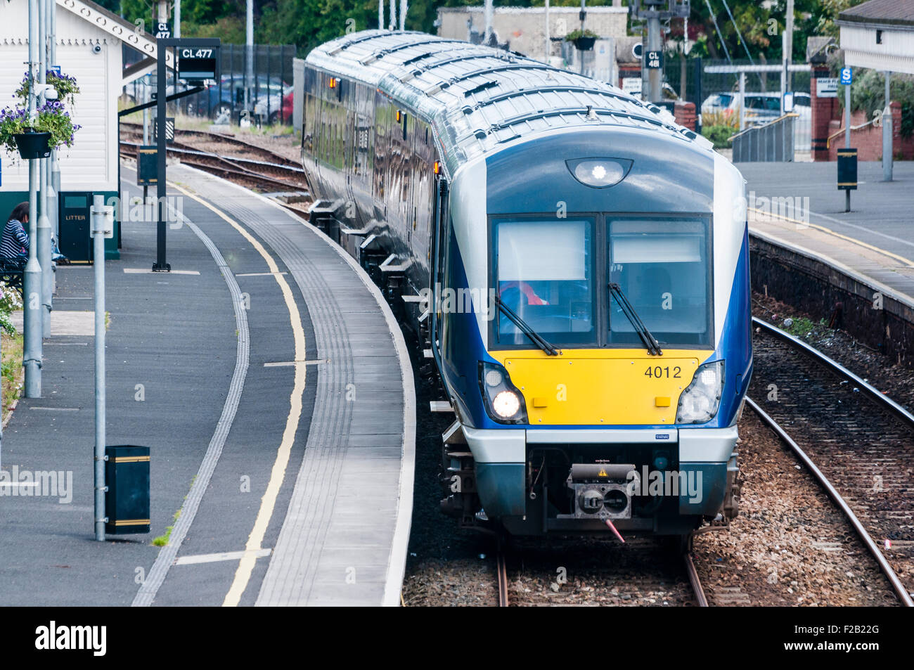 A Northern Ireland Railways train waits at a platform. Stock Photo