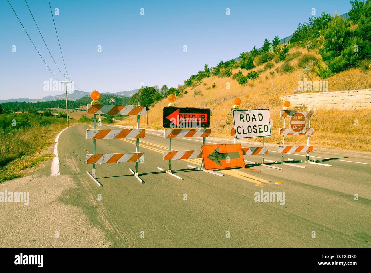 Road closed and detour signs across road in California Stock Photo
