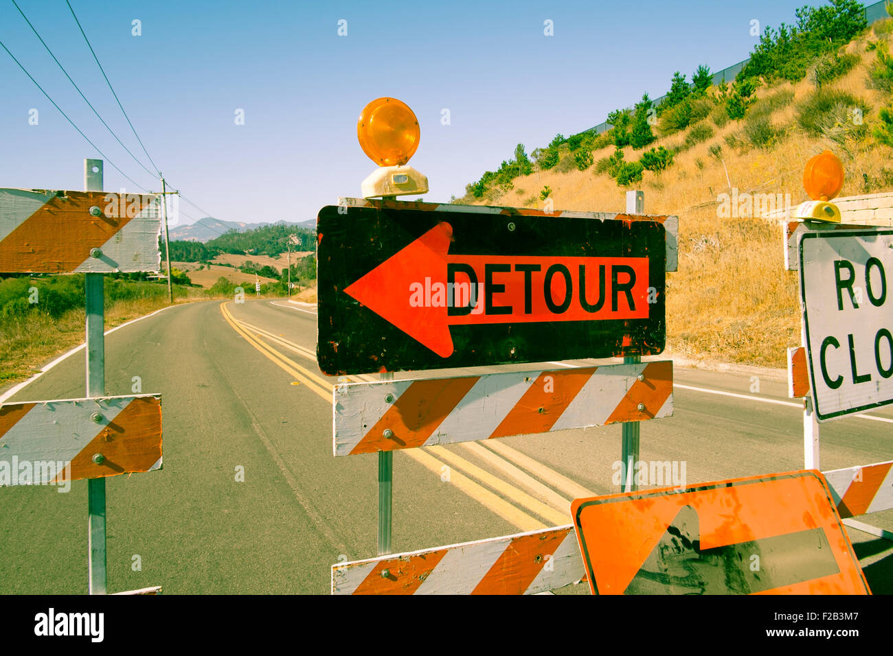 Road closed and detour signs across road in California Stock Photo
