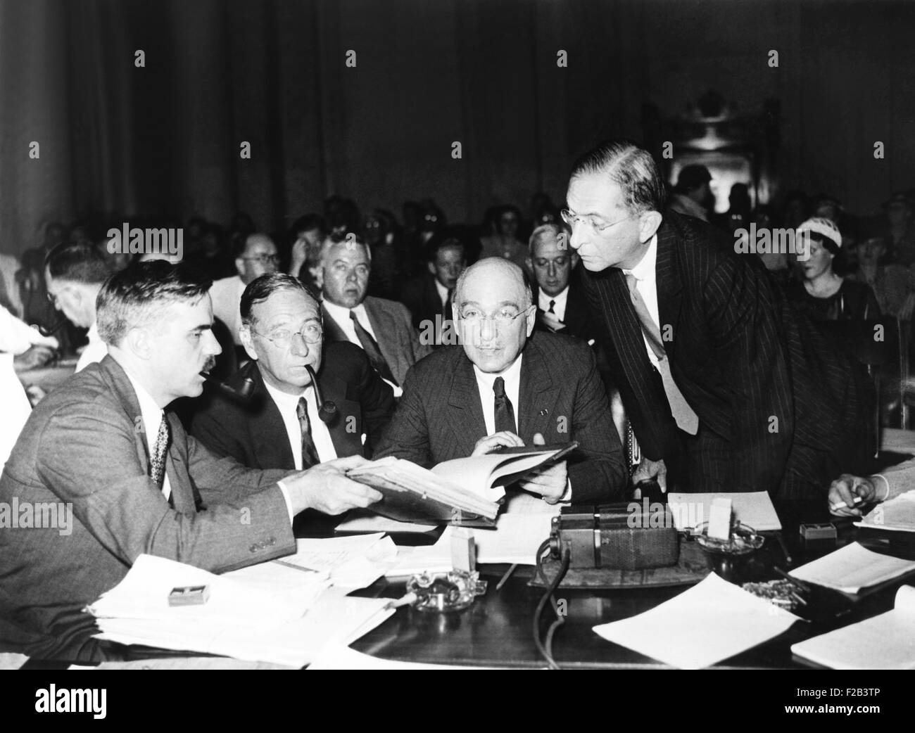Senate Munitions Investigating Committee, Sept. 12, 1934. L-R: Stephen Rauschenbach, Chief Investigator for the Munitions Committee; Irenee, Pierre, and Lammot DuPont, looking over evidence at the witness stand. - (CSU 2015 5 47) Stock Photo