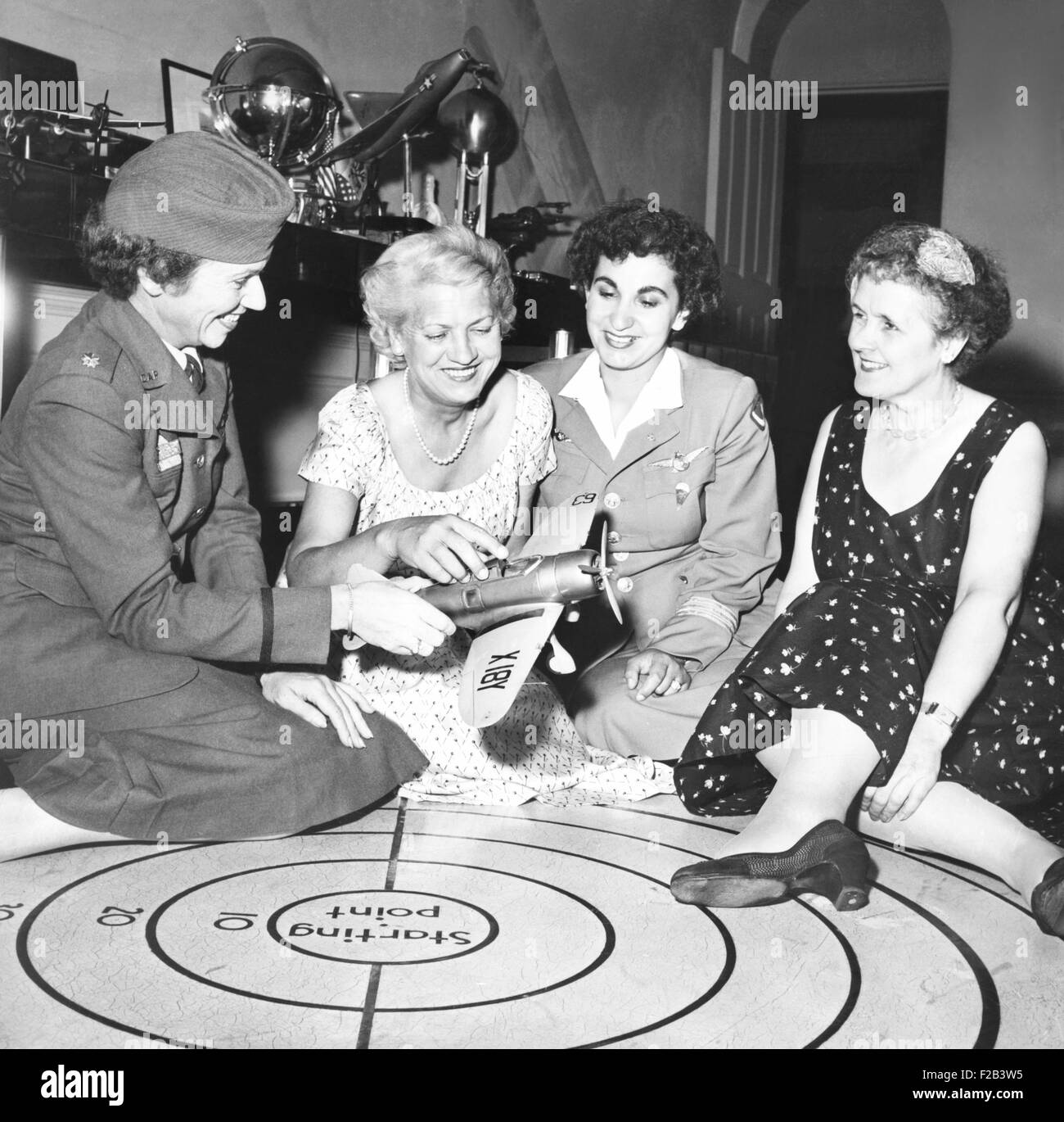 Jacqueline Cochran (2nd from left) and famous women flyers talk shop at her NYC apartment. L-R: Jean Howard, of Washington, D.C., a Major in the Civilian Air Patrol; Edibe Subasu, who teaches Turkish Air Cadets how to parachute; and Ruth Nichols. Miss Cochrane gave a dinner to mark the windup of the visit of 180 foreign aviation cadets from 20 countries. The Turkish aviatrix, Edibe Subasu, headed the contingent from her country. Aug. 11, 1954. - (CSU 2015 5 38) Stock Photo
