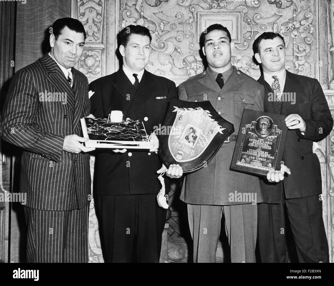 Four boxing champions at the Annual Dinner of the Boxing Writer's Assn. At the Ruppert Brewery in NYC. Jan. 21, 1942. L-R: Holding three awards presented at the dinner are: Jack Dempsey, Lt. Cmdr. Gene Tunney, Private Joe Louis, and James  Braddock. The trophies are, L-R: Boxing Writers Award to Gene Tunney for his services to his country and to boxing; Ring Magazine Merit Award for 1941, given with the Edward J. Neil Trophy, to Joe Louis. - (CSU 2015 5 155) Stock Photo