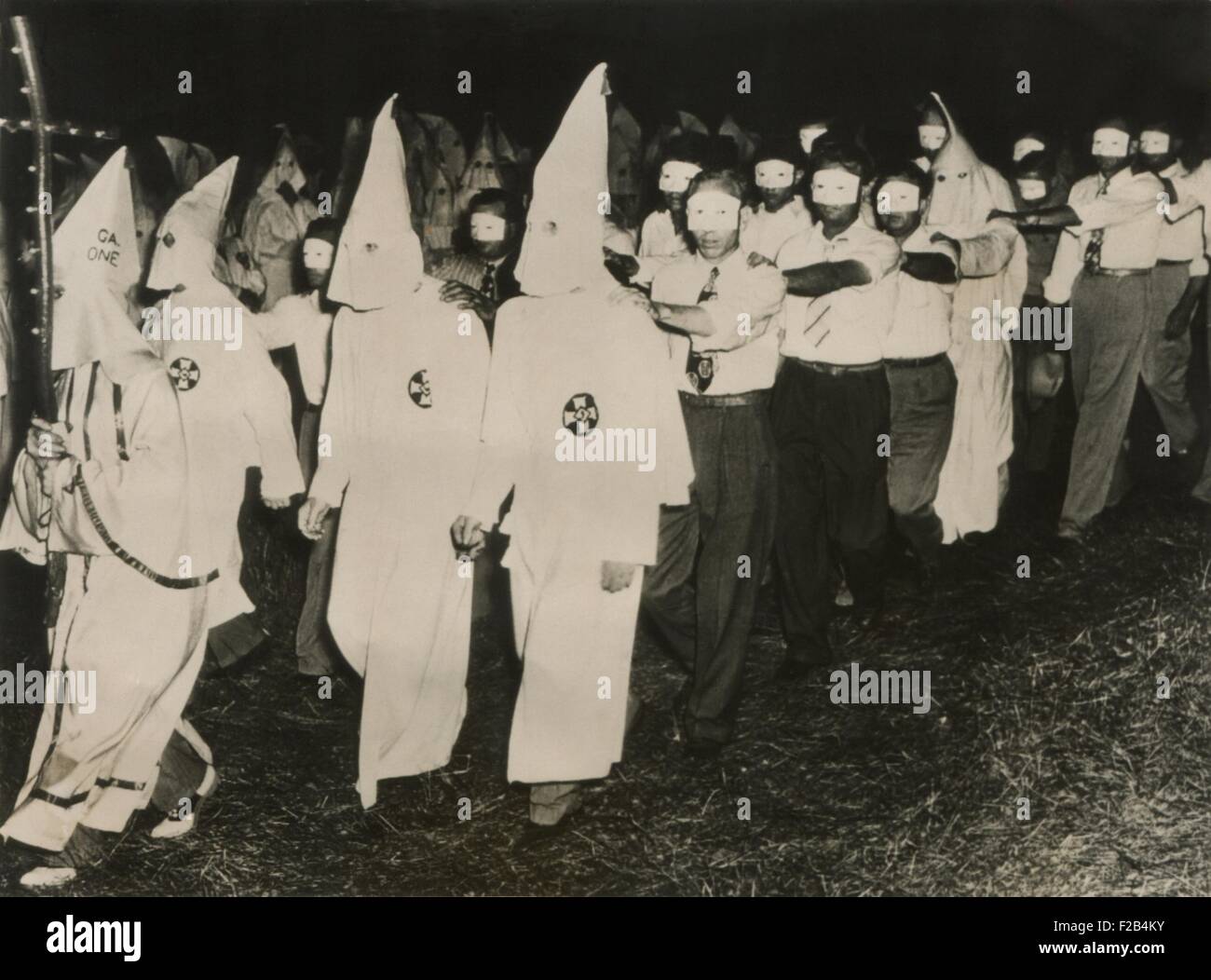 Ku Klux Klan initiation at Stone Mountain near Atlanta, Georgia. June 1949. KKK men in full white masks and gowns lead new members wearing small face masks. - (BSLOC 2015 1 208) Stock Photo