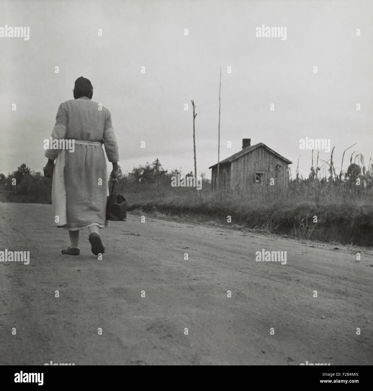 African American Midwife carrying her medical bag on a dirt road in Georgia. Nov. 1941 photo by Jack Delano. - (BSLOC 2015 1 189) Stock Photo