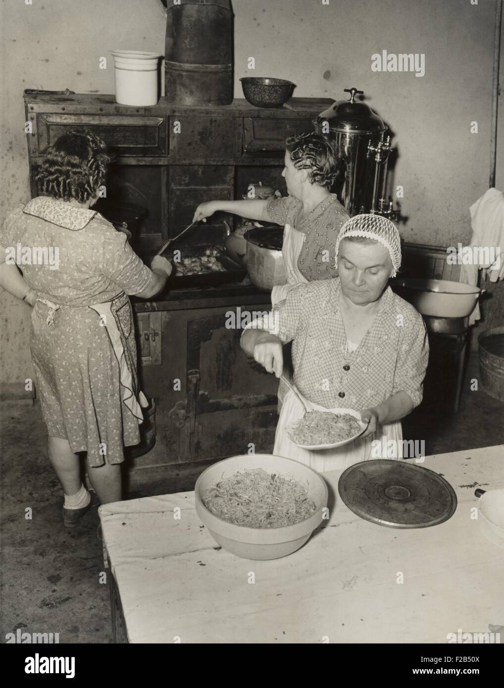 Women cooking spaghetti and frying chicken on an old stove for the Grape Festival. Tontitown, Arkansas. August 16, 1941. - (BSLOC 2015 1 166) Stock Photo