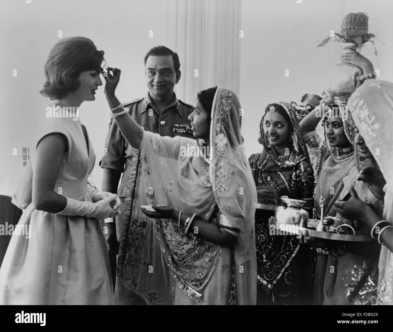 Jacqueline Kennedy having a 'bindi' placed on her forehead at Jaipur, India. A bindi is a red dot on the forehead which is a sign of marriage. - (BSLOC 2015 1 133) Stock Photo