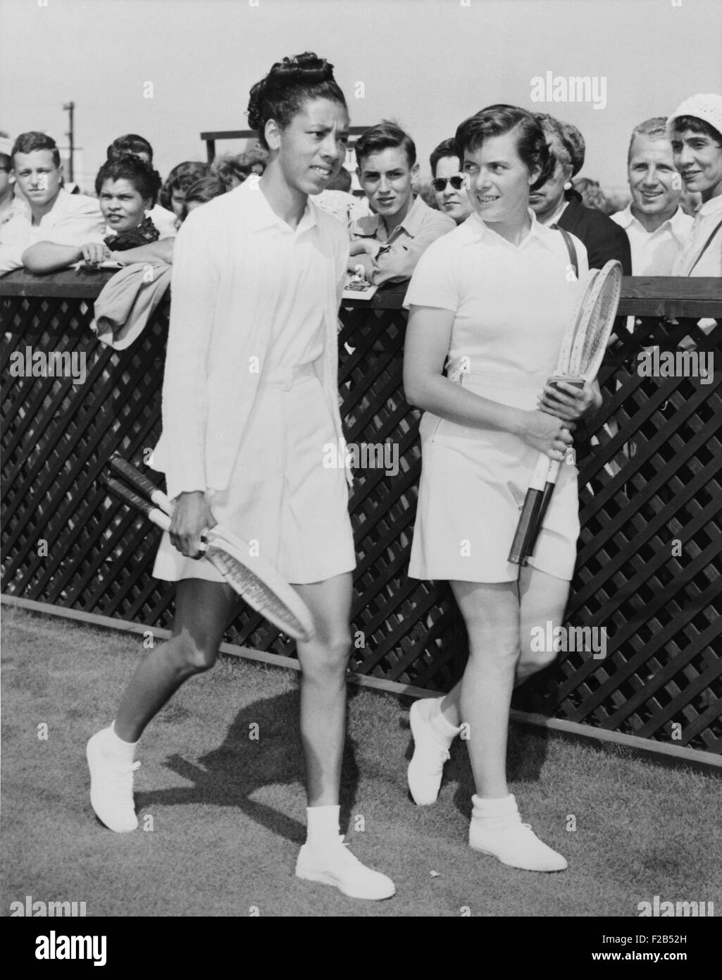 Althea Gibson and Barbara Knapp walk on grass at Forest Hills in 1950. Gibson won 10 straight championships in 1947 in the segregated ATA (American Tennis Association). When the USLTA (U.S. Lawn Tennis Association) failed to invite her to any qualifying tournaments, Alice Marble, a four-time winner at Forest Hills, protested and accused bigotry. The next year Gibson played at Forest Hills. - (BSLOC 2015 1 126) Stock Photo