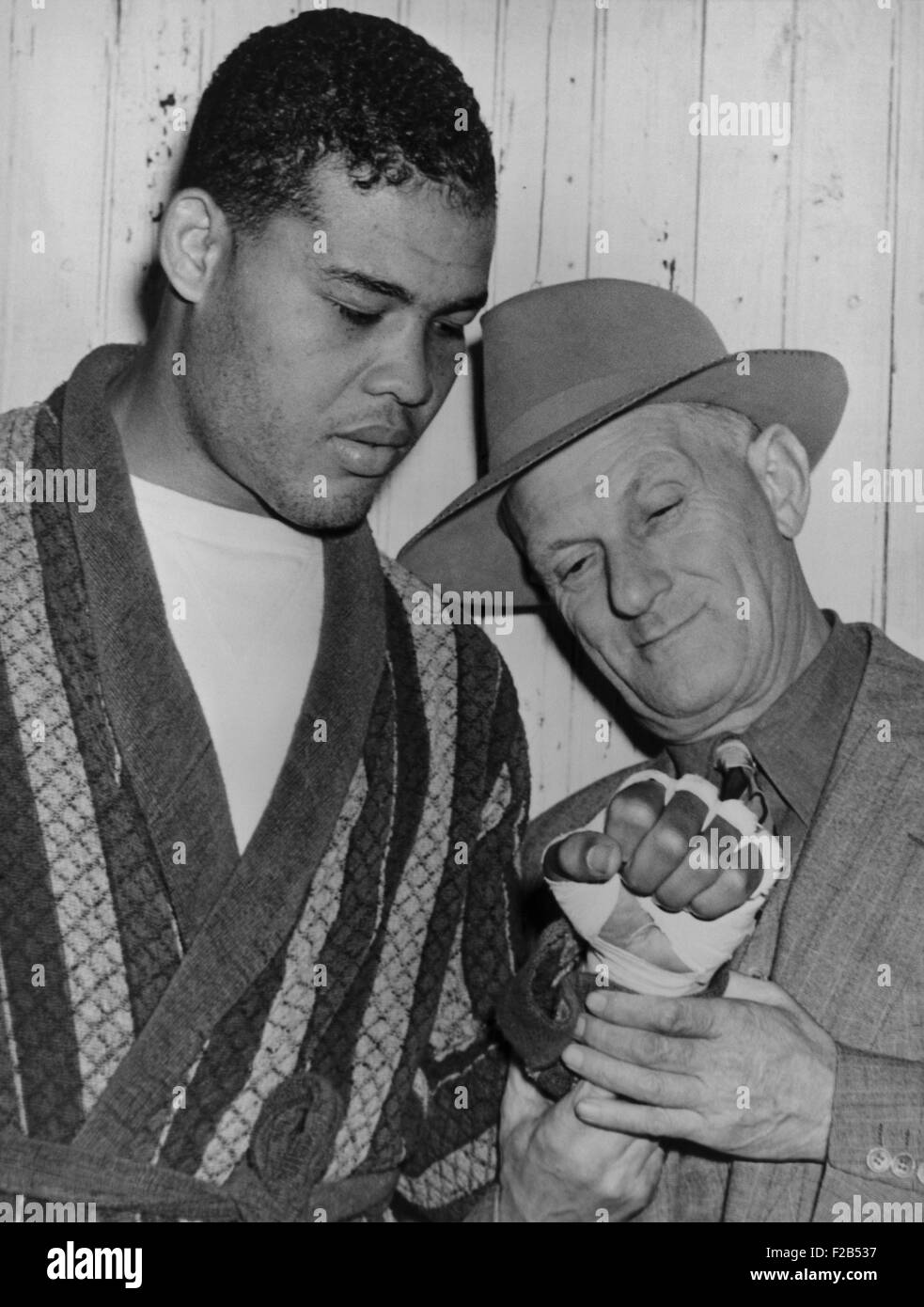 Mike Jacobs inspects Joe Louis' fist before the heavy weight champion would defend his title against Lou Nova on Sept. 29, 1941. In 1935 Jacobs worked to overcome informal barriers that kept African American boxers out of big title fights. Two years later, Louis won the World Championship against James Braddock on June 22, 1937. - (BSLOC 2015 1 110) Stock Photo