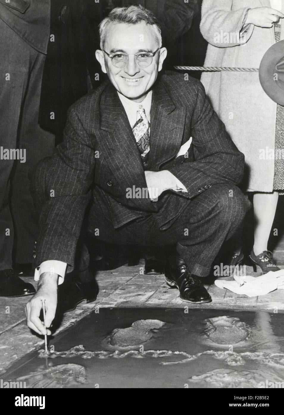 Dale Carnegie, signing his concrete slab at Grauman's Chinese Theatre. His book, 'How To Win Friends and Influence People' of 1931 is a classic and still relevant self-help book. Ca. 1930s. - (BSLOC 2014 17 201) Stock Photo