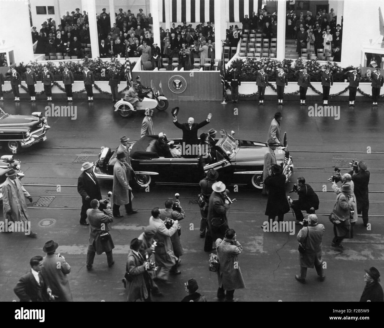 Eisenhower waves from an open car in the inaugural parade. Behind him is the White House Inaugural pavilion. Jan. 21, 1957. - (BSLOC 2014 16 36) Stock Photo