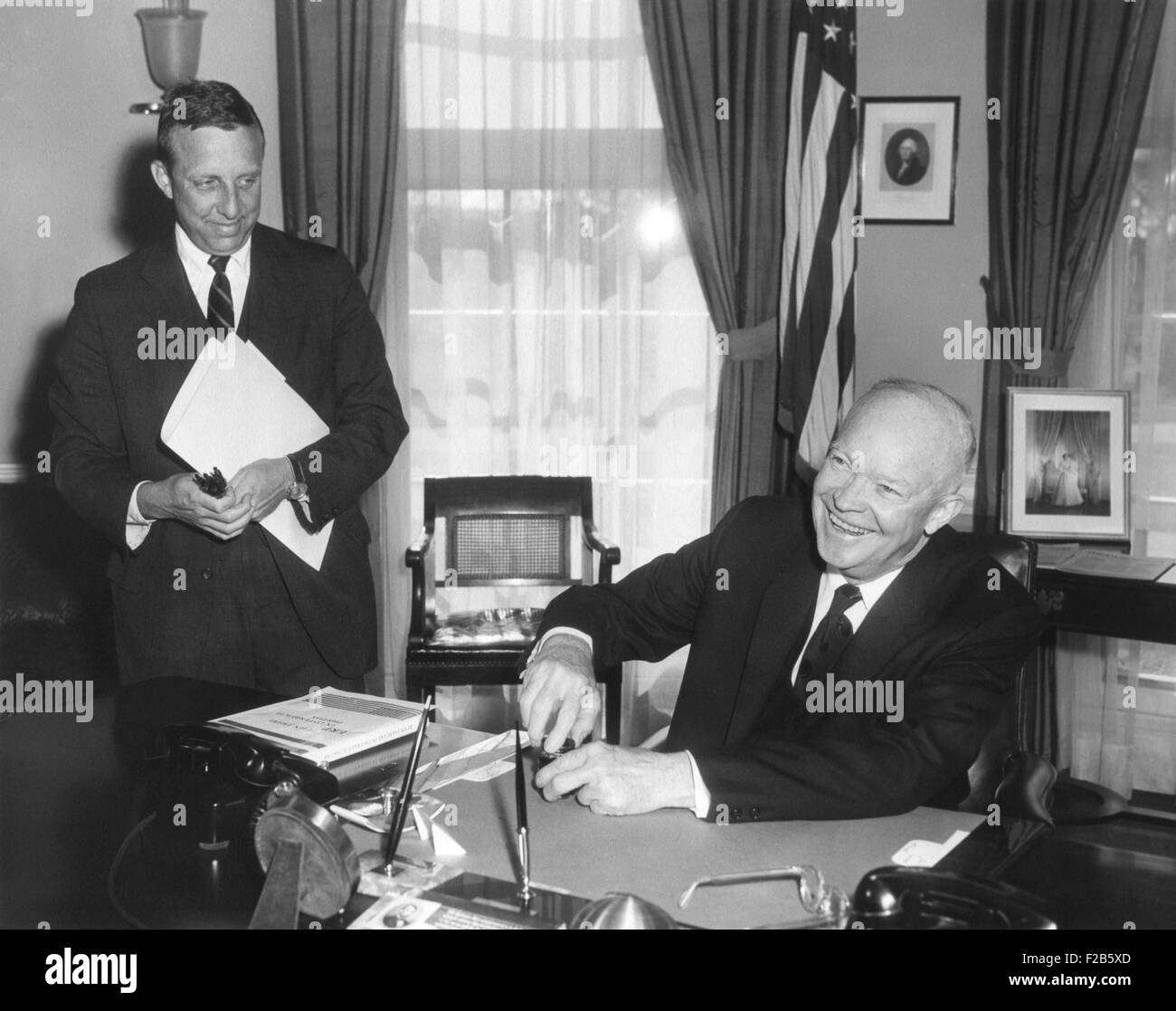 President Eisenhower is signing the Hawaii Statehood Bill in the Oval Office on March 18, 1959. At left is Henry McPhee, Associate Special Counsel to the President, who assisted with economic and legal matters. - (BSLOC 2014 16 239) Stock Photo