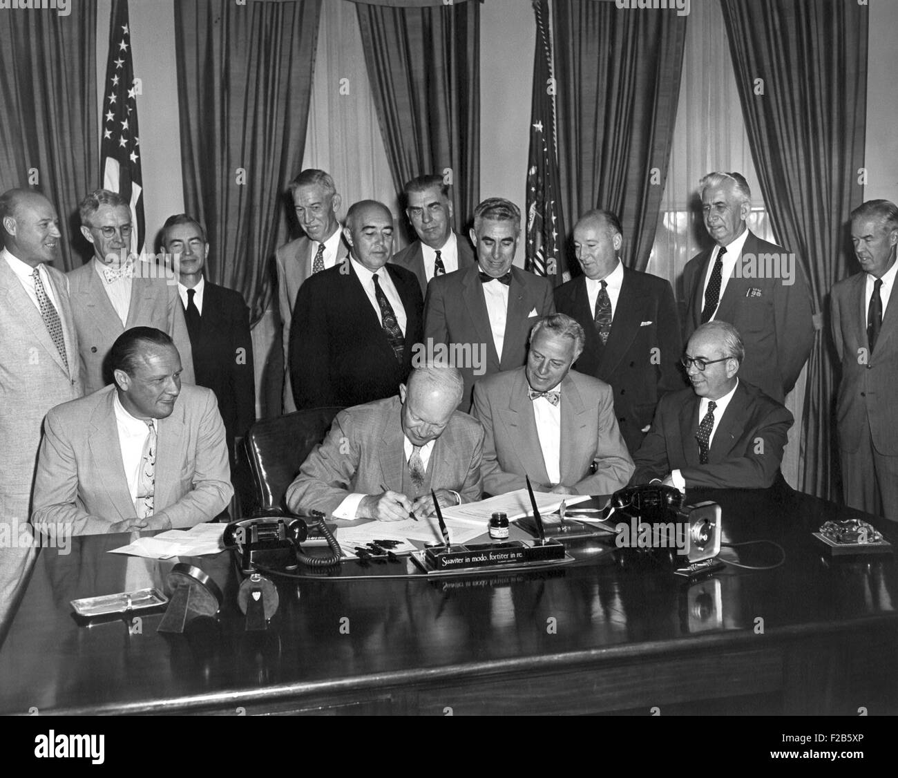 President Eisenhower signs the Atomic Energy Act of 1954. Aug. 8, 1954. Standing behind Eisenhower is Henry DeWolf Smyth (bowtie), a key physicist in the development of nuclear energy. Seated far right is Lewis Strauss, Chairman, Atomic Energy Commission. - (BSLOC 2014 16 234) Stock Photo