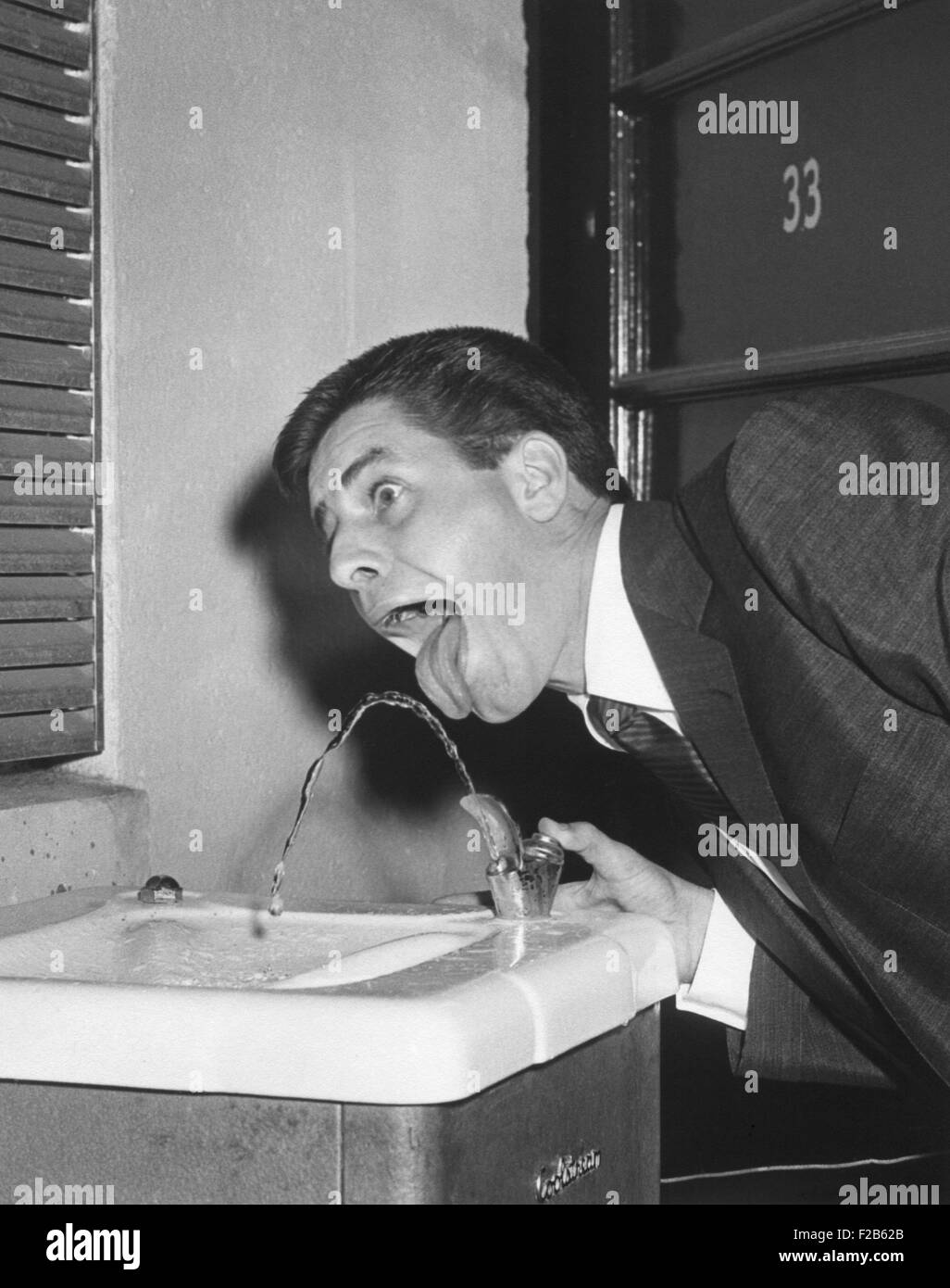 Jerry Lewis providing White House Photographer, Abbie Rowe, with a comic image at water fountain. July 25, 1957. - (BSLOC 2014 16 167) Stock Photo