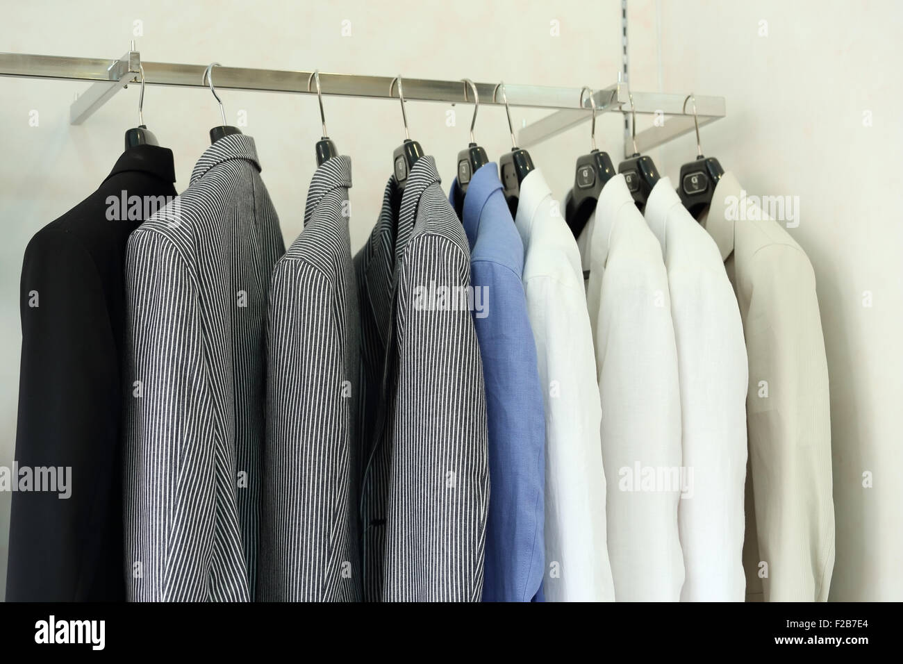 Row of men's suit jackets hanging in a retail shop Stock Photo