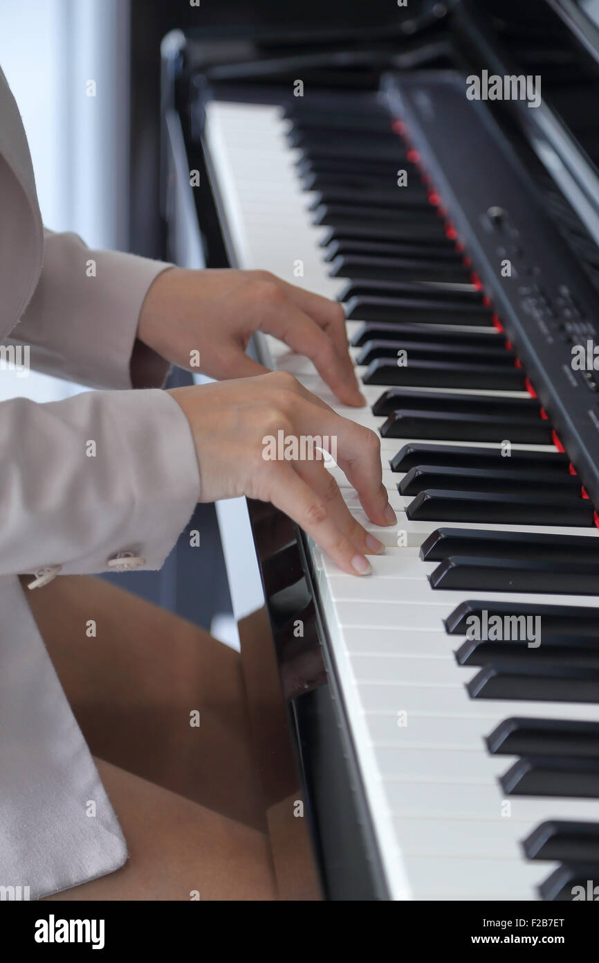 hands of a young woman playing piano Stock Photo