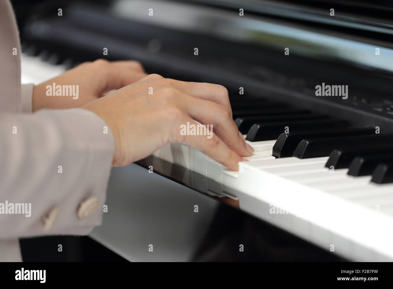 Close up of the hands of a young woman playing piano Stock Photo