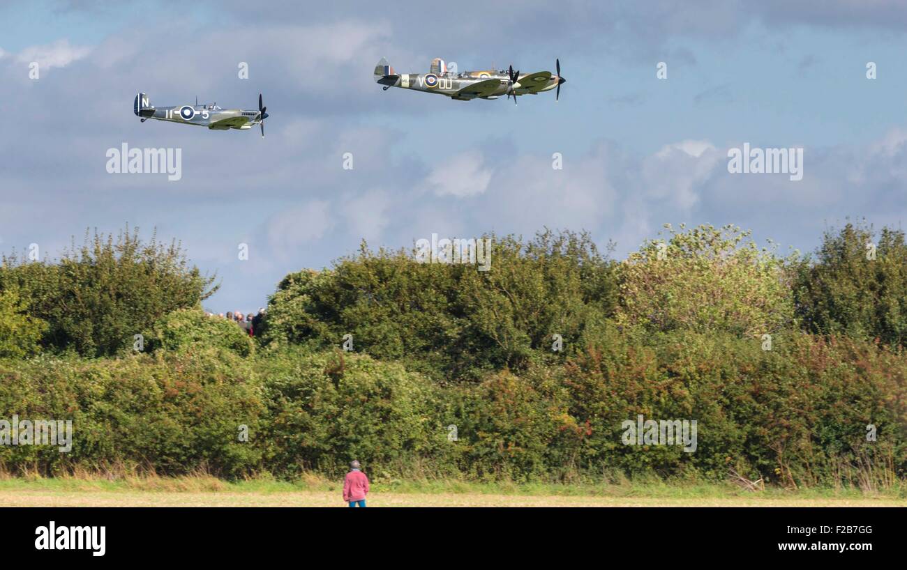 Members of the public watch Spitfires and other World War II aircraft take of from Goodwood airfield near Chichester Stock Photo