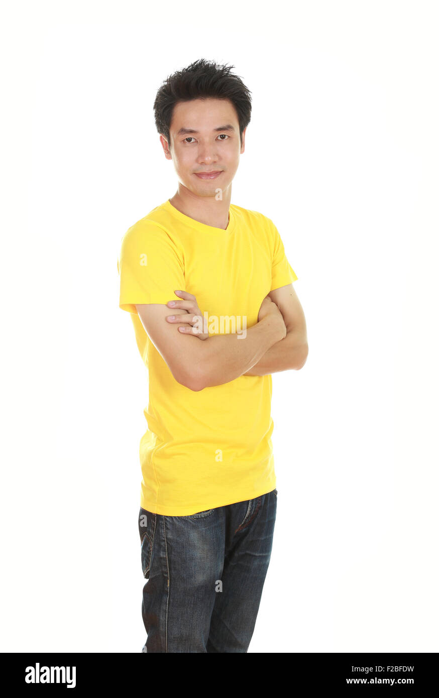 man with arms crossed, wearing yellow t-shirt isolated on white background. Stock Photo
