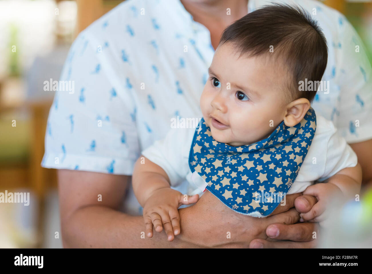 Multi ethnic baby male baby held by his father Stock Photo