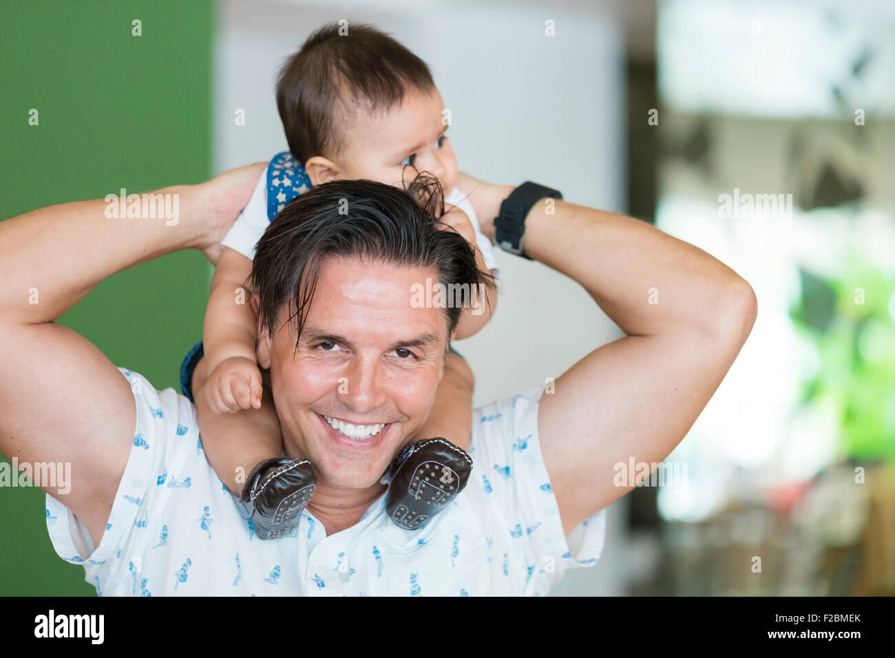 Multi ethnic family - father with infant son on his shoulders Stock Photo