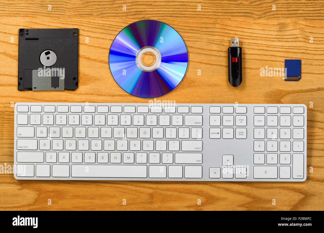 Top view of desktop with keyboard, diskette, CD, thumb drive, and Flash disk. Concept of portable data storage device Stock Photo