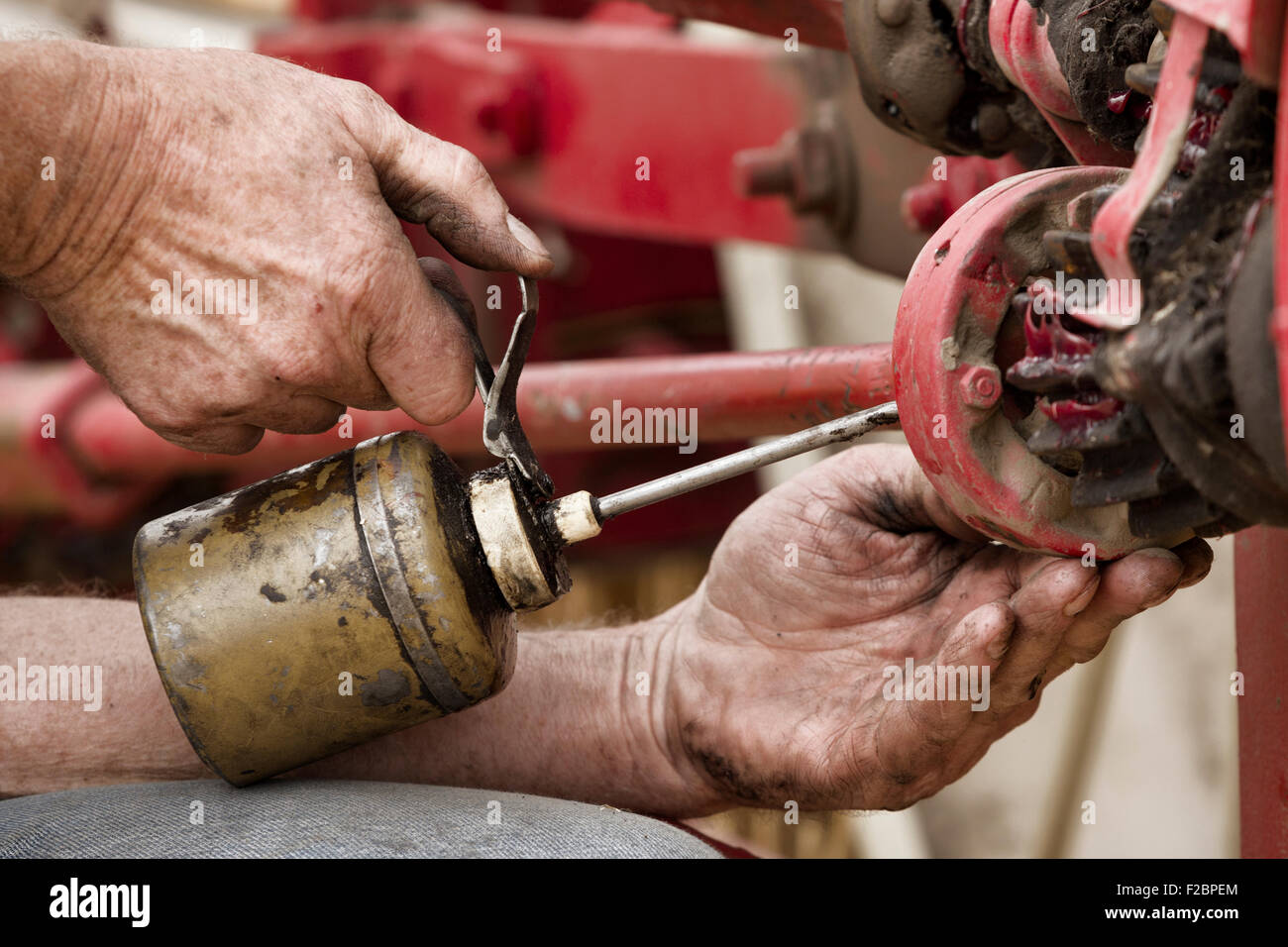 https://c8.alamy.com/comp/F2BPEM/the-hands-of-a-man-using-an-old-oil-can-to-grease-the-machinery-F2BPEM.jpg