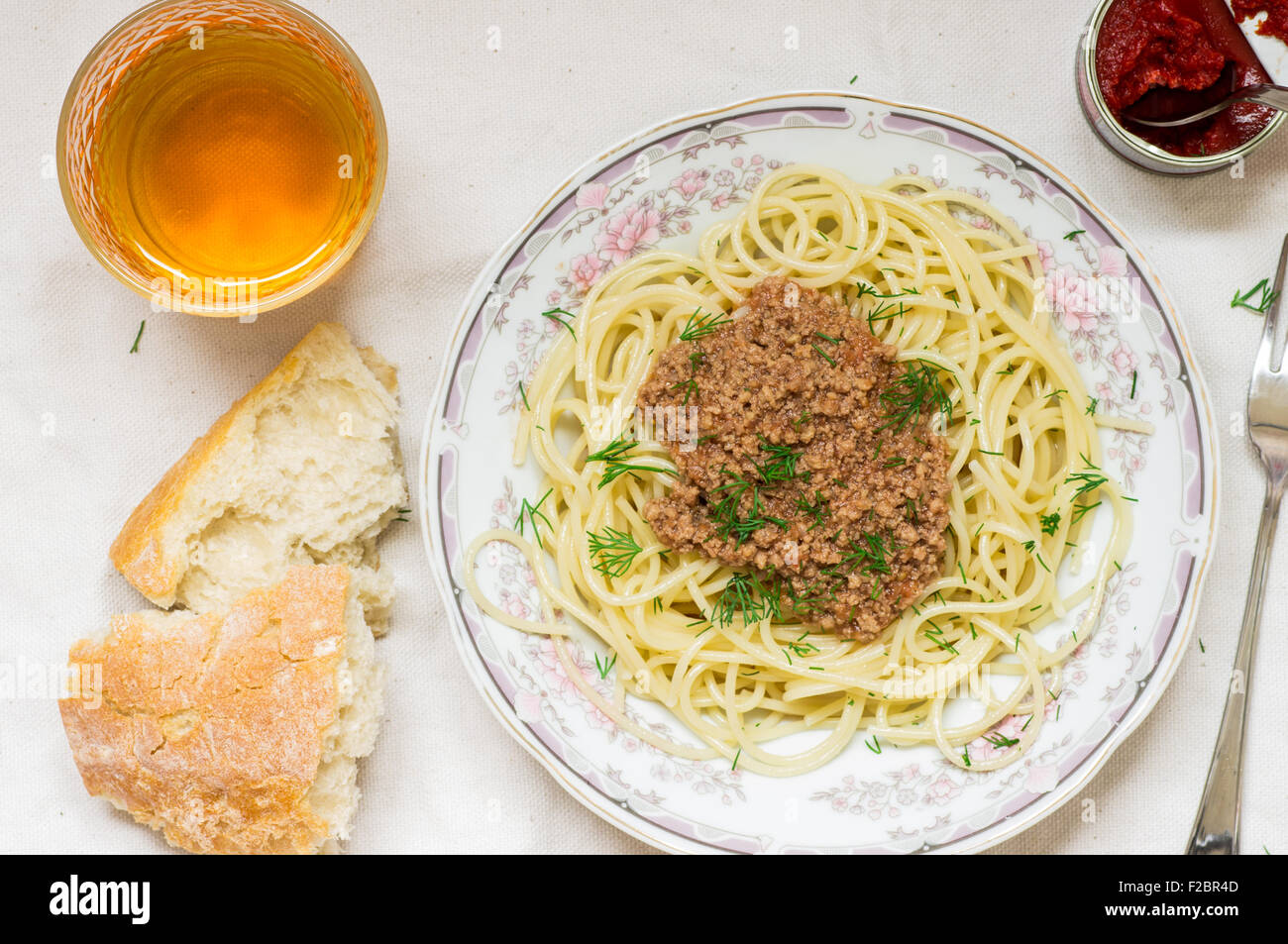 Spaghetti bolognese pasta in a dish and white wine glass Stock Photo