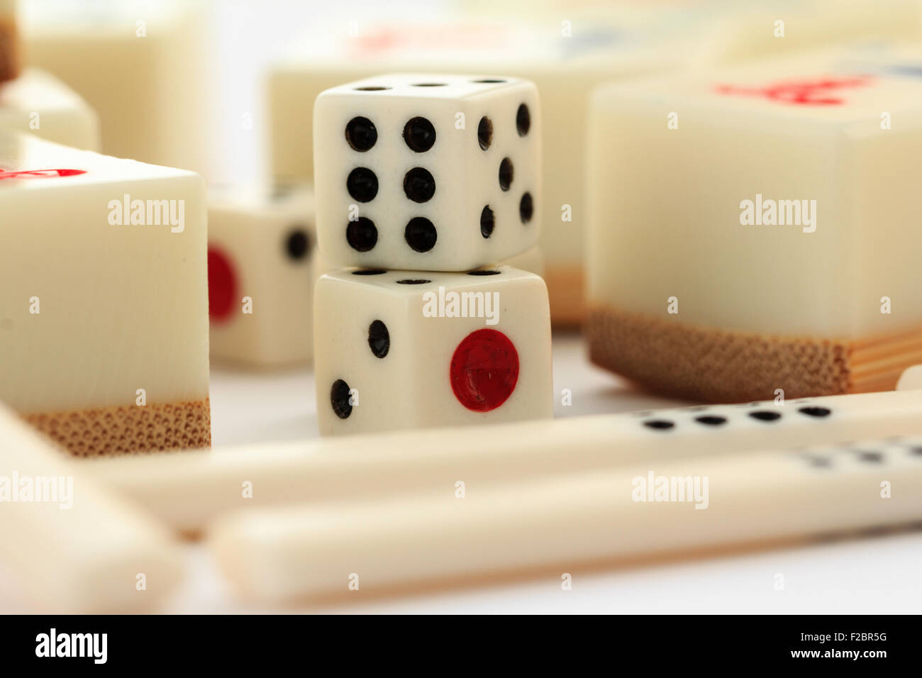 Mahjong, Mah jong gambling set. Various cards or tiles, dice and some counters laying on plain white background. Stock Photo