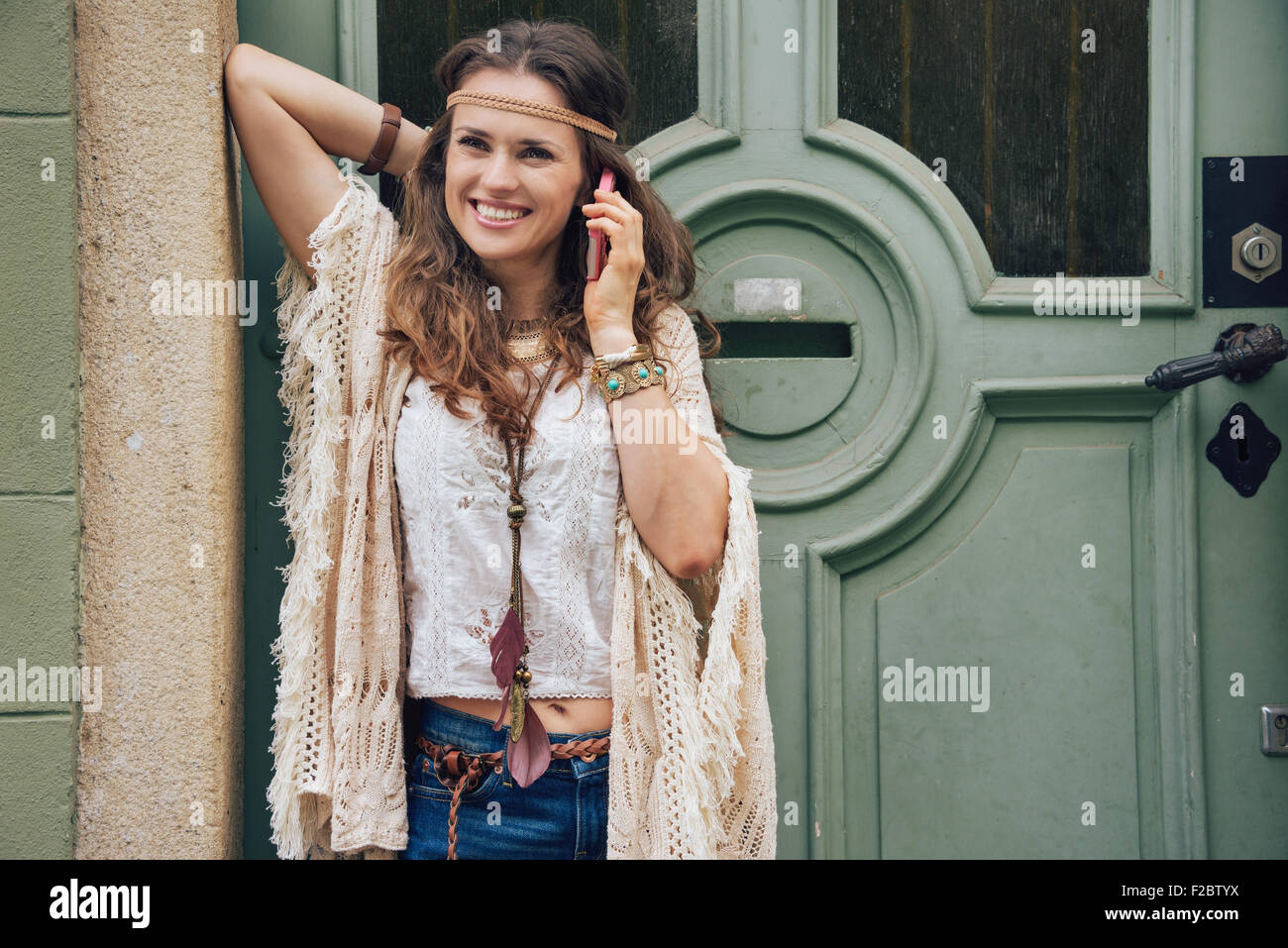 Happy woman wearing bohemian style clothes standing outside buildings in  street and talking cell phone Stock Photo - Alamy