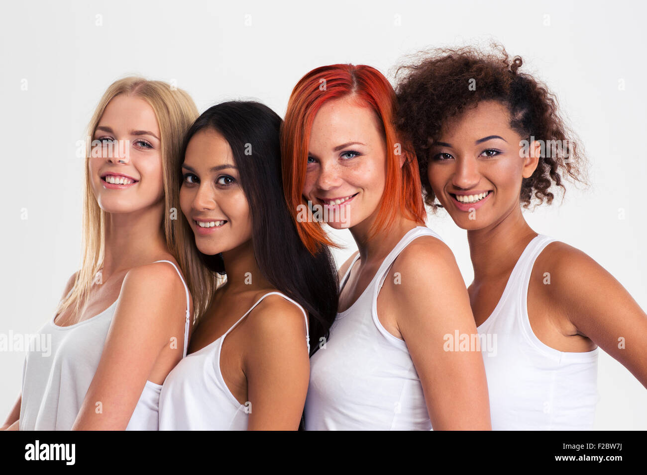 Portrait of a four girls standing in a row and looking at camera isolated on a white background Stock Photo