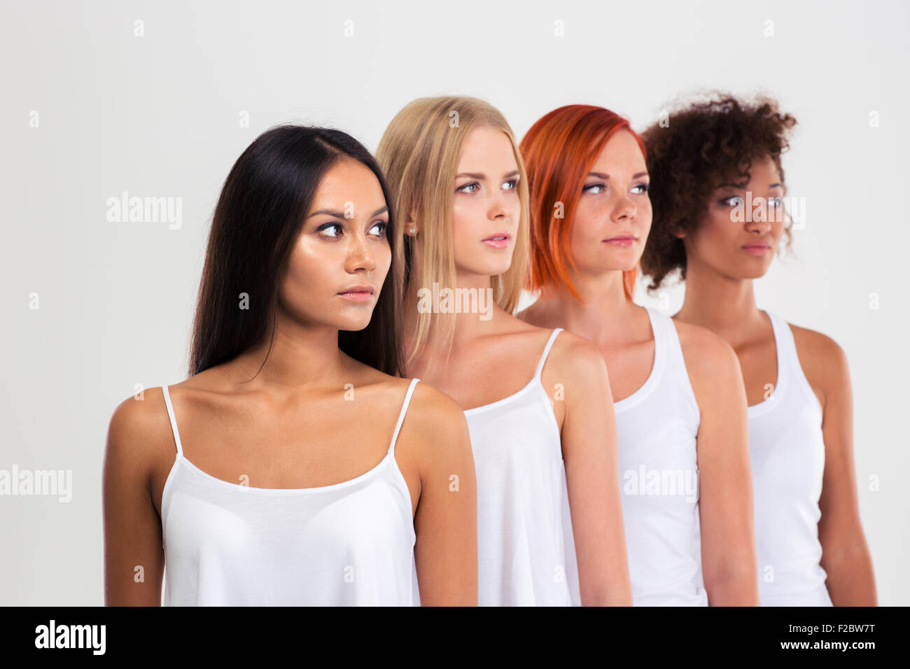 Portrait of a four women standing in a raw and looking away isolated on a white background Stock Photo