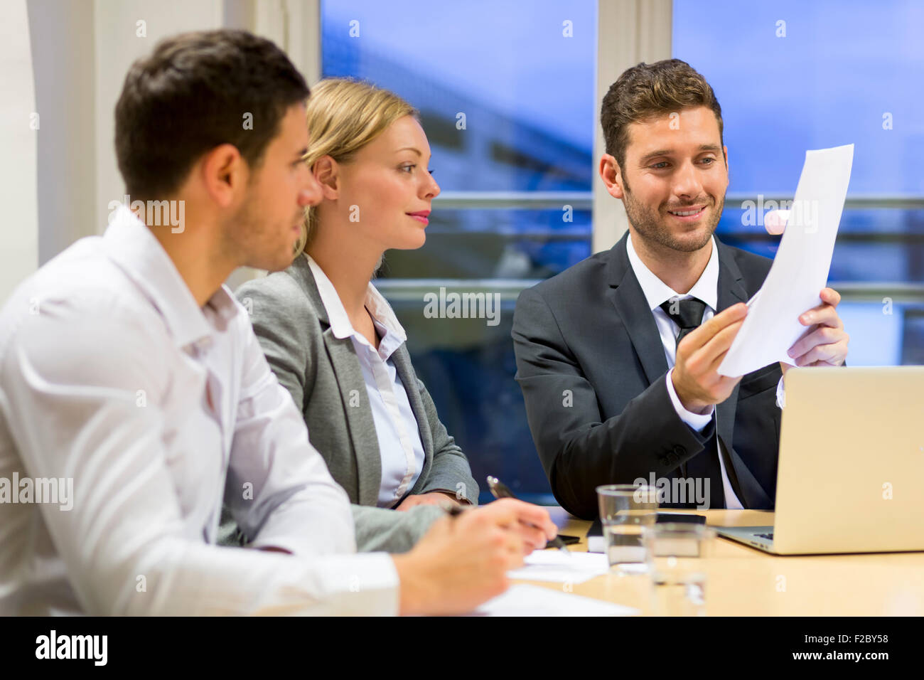 Businessmen and women arguing across boardroom table Stock Photo