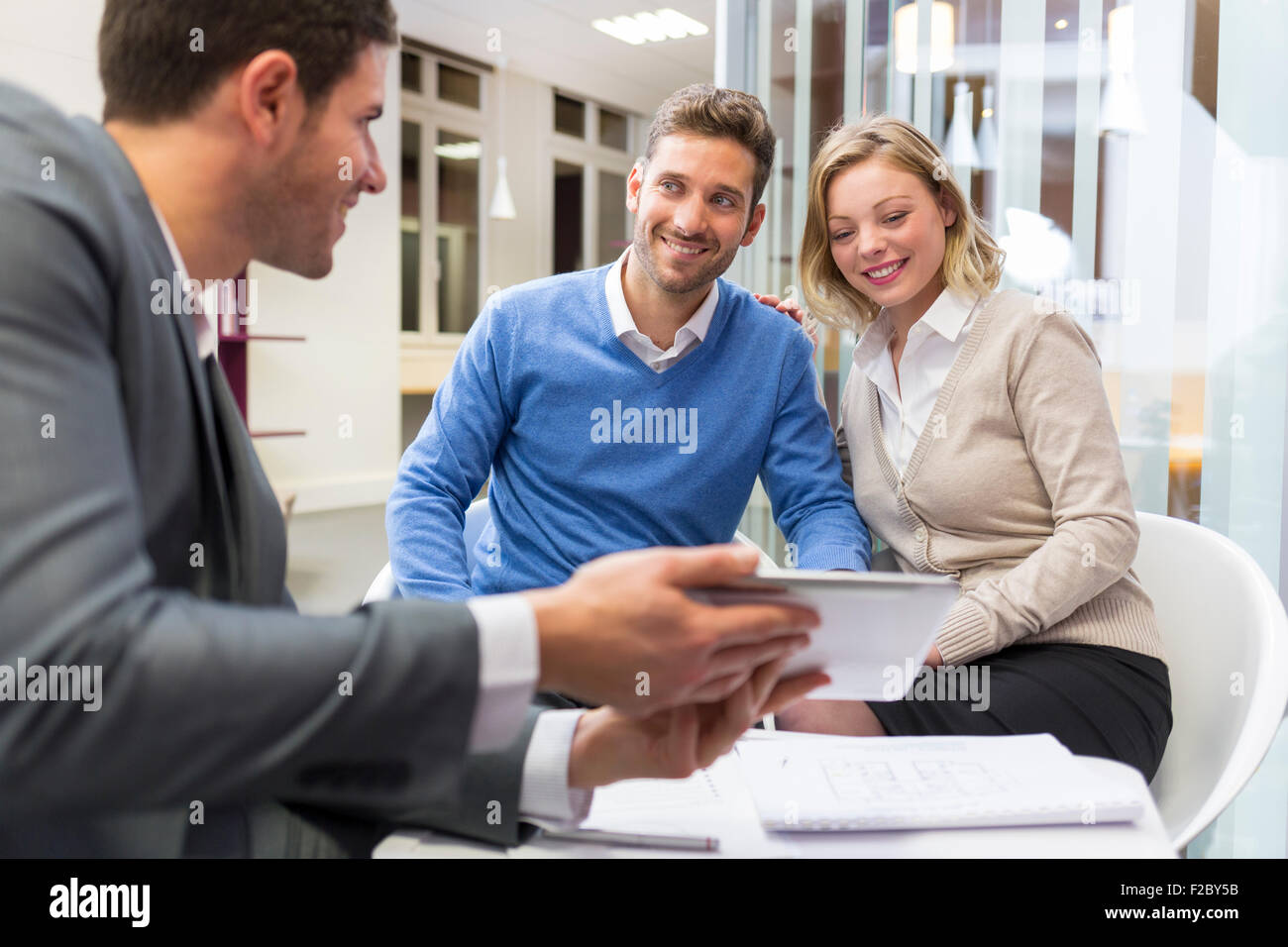 financial advisor using digital tablet and meeting with couple in office Stock Photo