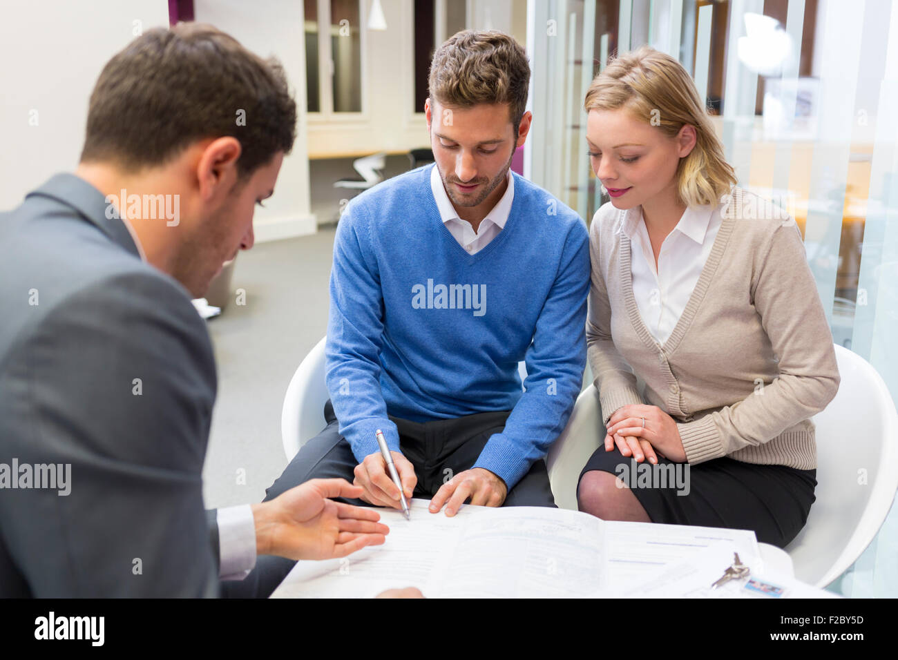 Couple signing contract with financial advisor Stock Photo