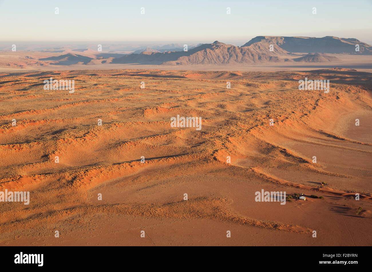 Farmhouse at the foot of a large grass-grown dune at the edge of the Namib Desert, aerial view from a hot-air balloon Stock Photo